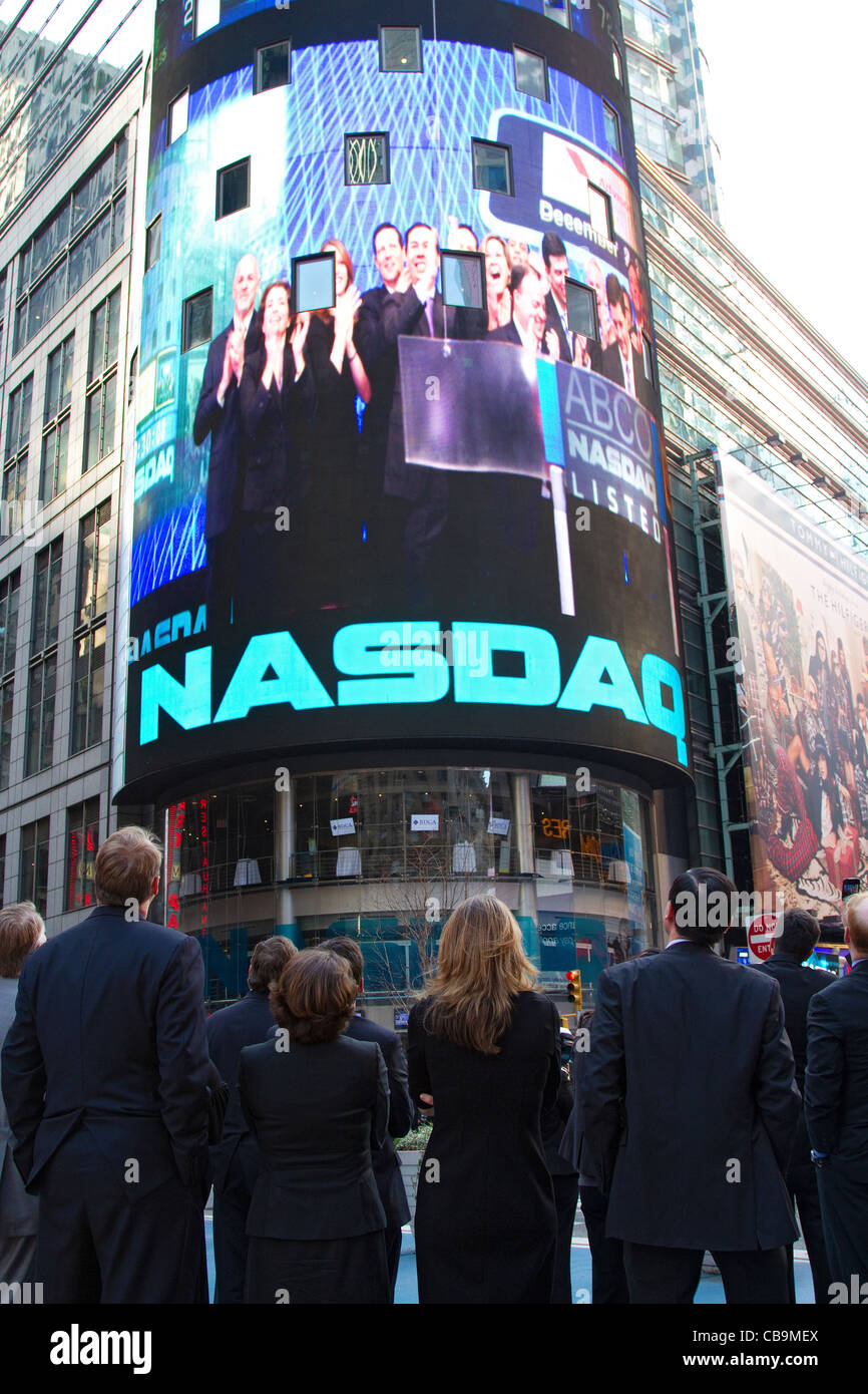 Bâtiment NASDAQ et signer à New York, Times Square avec hommes et de femmes d'affaires. Banque D'Images Bâtiment NASDAQ et signer à New York, Times Square avec hommes et de femmes d'affaires. Banque D'Images