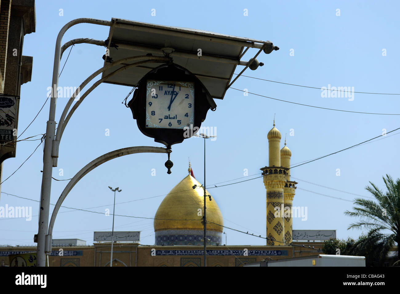 L'Irak, Kerbala. L'Imam Hussein (Husayn) culte avec horloge en premier plan Banque D'Images