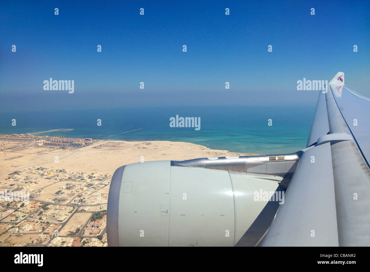 Vue à travers la fenêtre du passager jet avion de Qatar, aile Ciel et nuages Banque D'Images