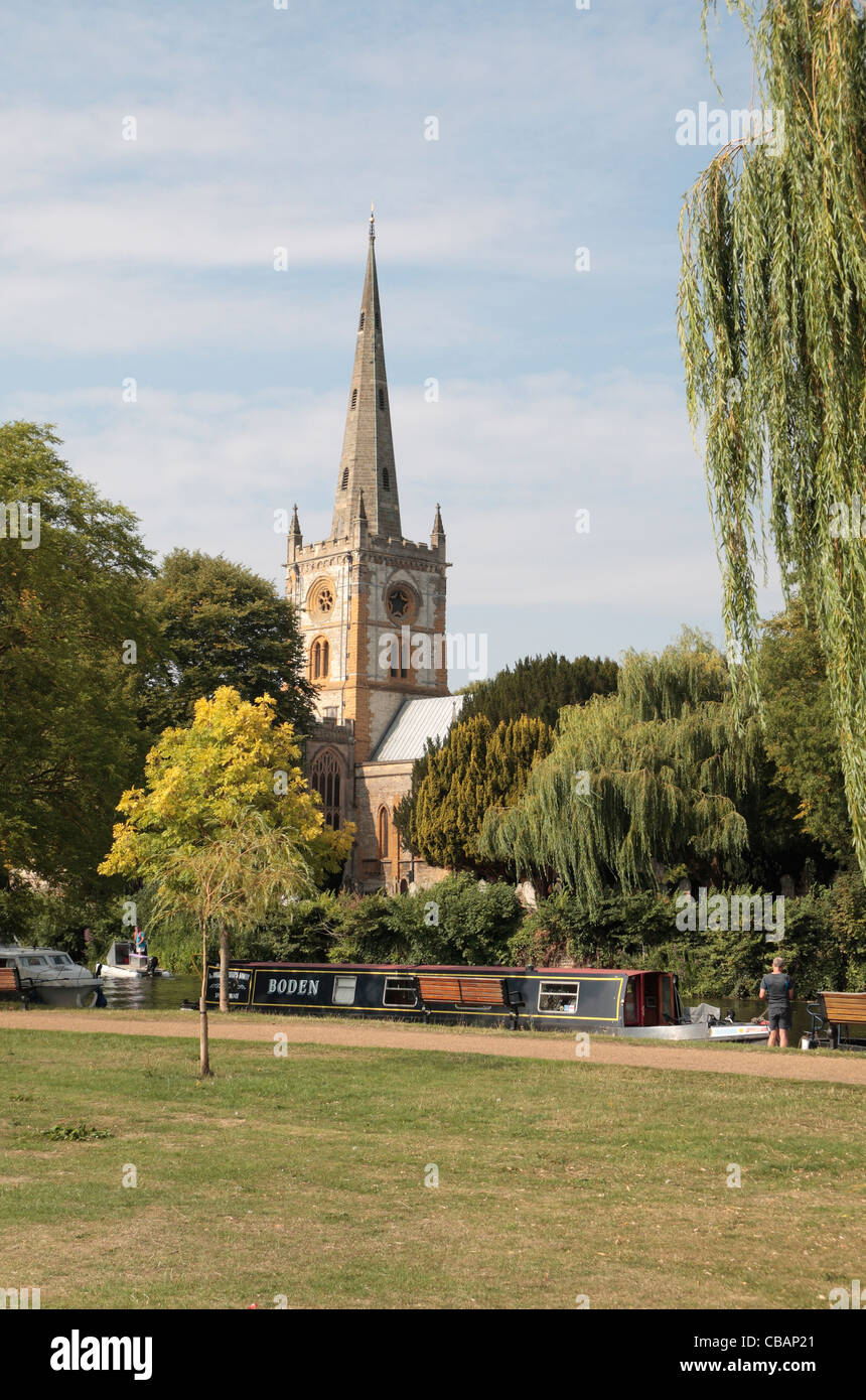 Canal bateaux amarrés sur la rivière Avon, à l'église Holy Trinity derrière, Stratford upon Avon, Warwickshire, Royaume-Uni. Banque D'Images