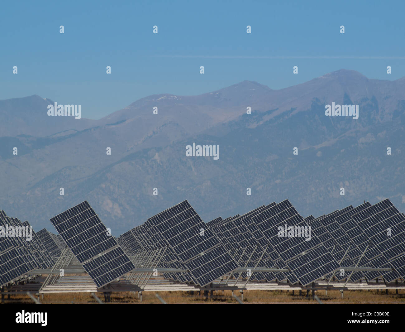 Une série de grands panneaux solaires forme une ligne symétrique à une centrale électrique dans la vallée de San Luis Colorado central. Ces panneaux utilisent un système de suivi pour suivre le soleil, la collecte de l'énergie et l'utilisation de cellules photovoltaïques pour transformer la lumière du soleil en électricité. Banque D'Images