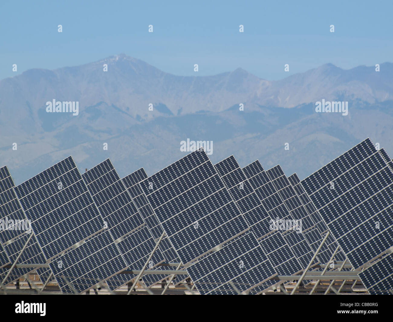 Une série de grands panneaux solaires forme une ligne symétrique à une centrale électrique dans la vallée de San Luis Colorado central. Ces panneaux utilisent un système de suivi pour suivre le soleil, la collecte de l'énergie et l'utilisation de cellules photovoltaïques pour transformer la lumière du soleil en électricité. Banque D'Images