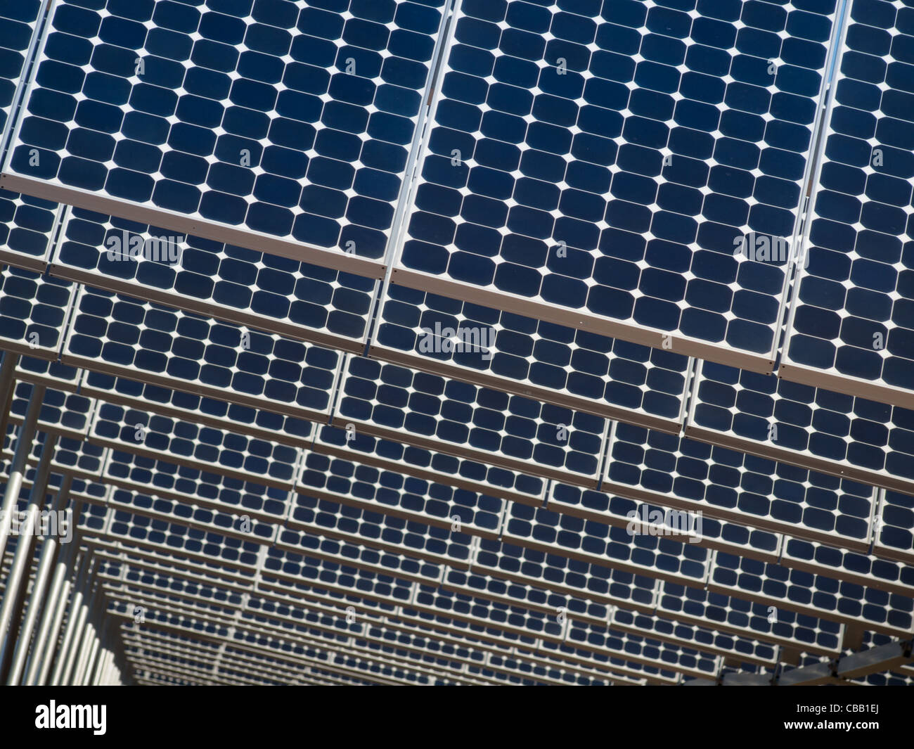 Une série de grands panneaux solaires forme une ligne symétrique à une centrale électrique dans la vallée de San Luis Colorado central. Ces panneaux utilisent un système de suivi pour suivre le soleil, la collecte de l'énergie et l'utilisation de cellules photovoltaïques pour transformer la lumière du soleil en électricité. Banque D'Images