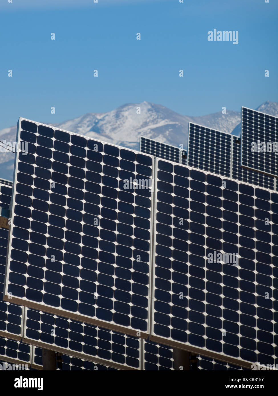 Une série de grands panneaux solaires forme une ligne symétrique à une centrale électrique dans la vallée de San Luis Colorado central. Ces panneaux utilisent un système de suivi pour suivre le soleil, la collecte de l'énergie et l'utilisation de cellules photovoltaïques pour transformer la lumière du soleil en électricité. Banque D'Images