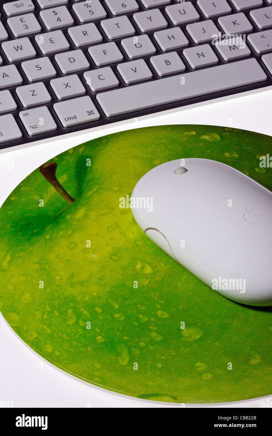 Close up de souris Apple sans fil sur un tapis de souris en forme d'Apple avec un clavier sans fil Apple sur un fond blanc Banque D'Images
