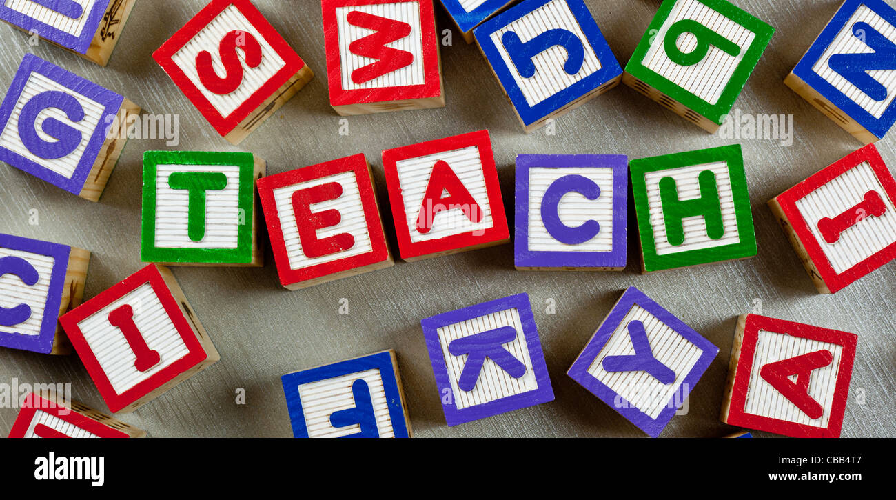 Des cales en bois formant le mot enseigner dans le centre Banque D'Images