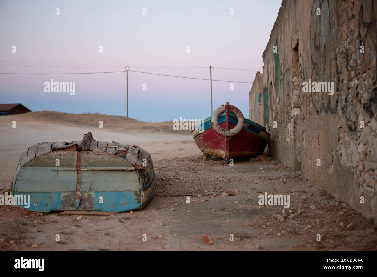 Vieux bateaux de pêche pose à côté d'un bâtiment abandonné Banque D'Images