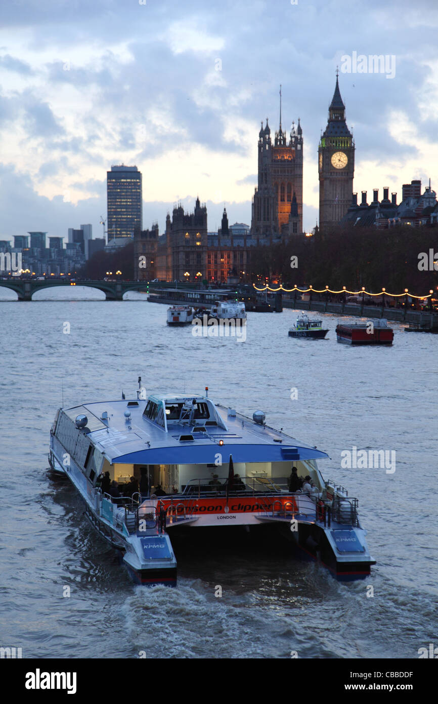 Thames Clipper ferry passager quitte la carbonisation Cross Pier au crépuscule. Chambres du Parlement et Big Ben sur l'arrière-plan Banque D'Images