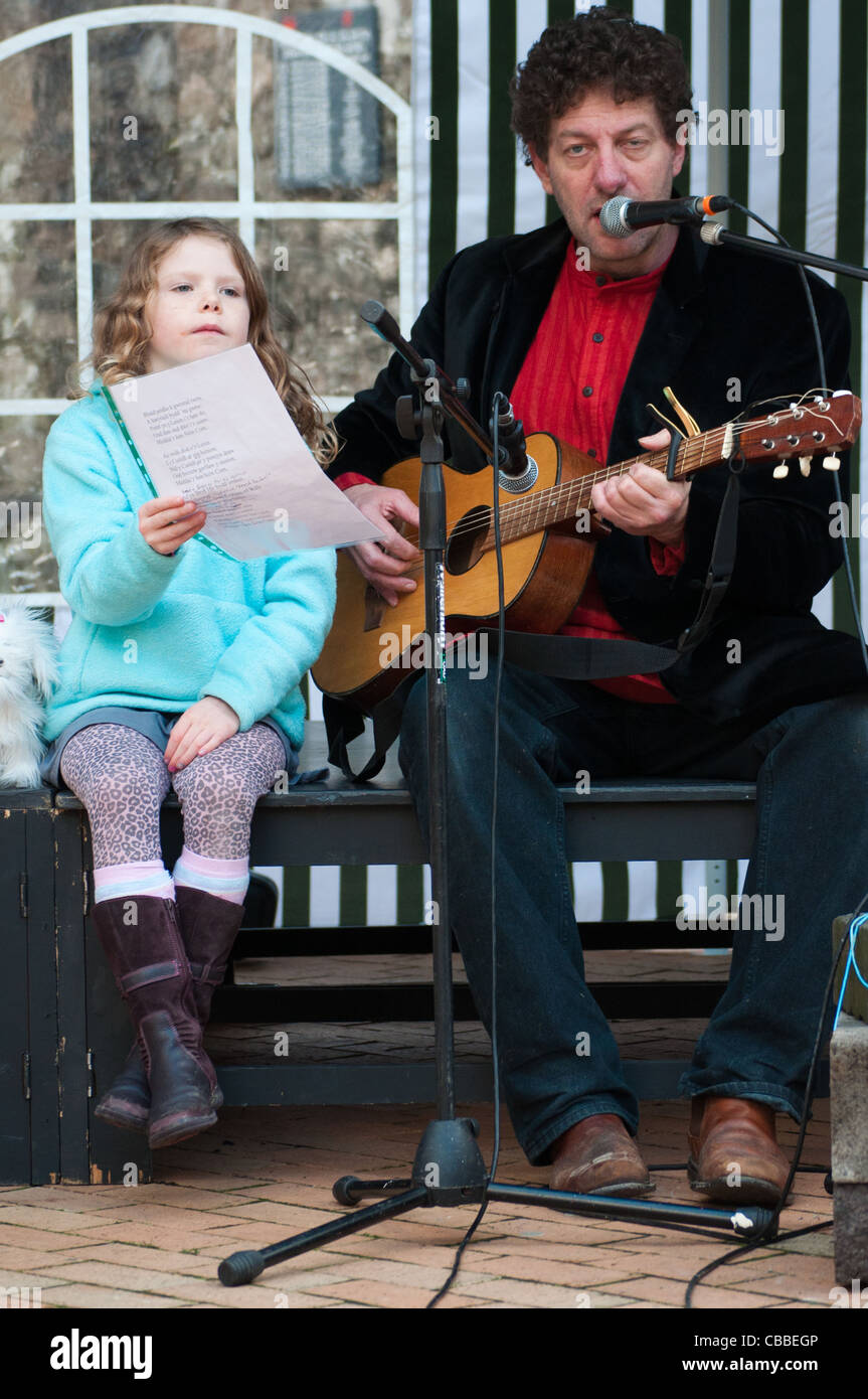 Girl holding music pour la chanteuse Twm Morris, effectuant à Cricieth Croeso 'Dolig Banque D'Images