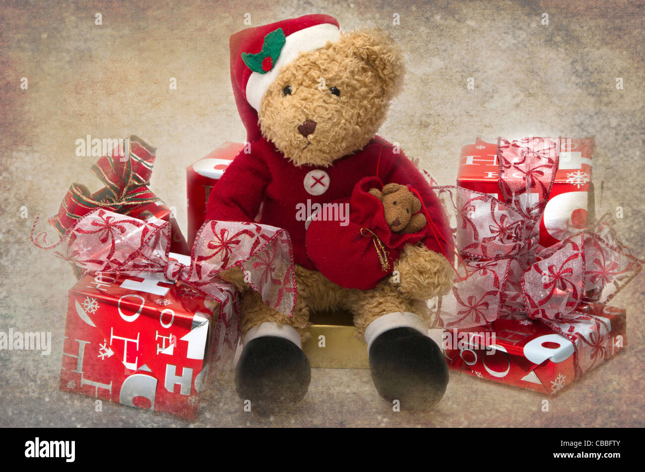 Ours en peluche à Noël. Bien aimé l'enfant ours en peluche habillée en père assis parmi des cadeaux. Banque D'Images