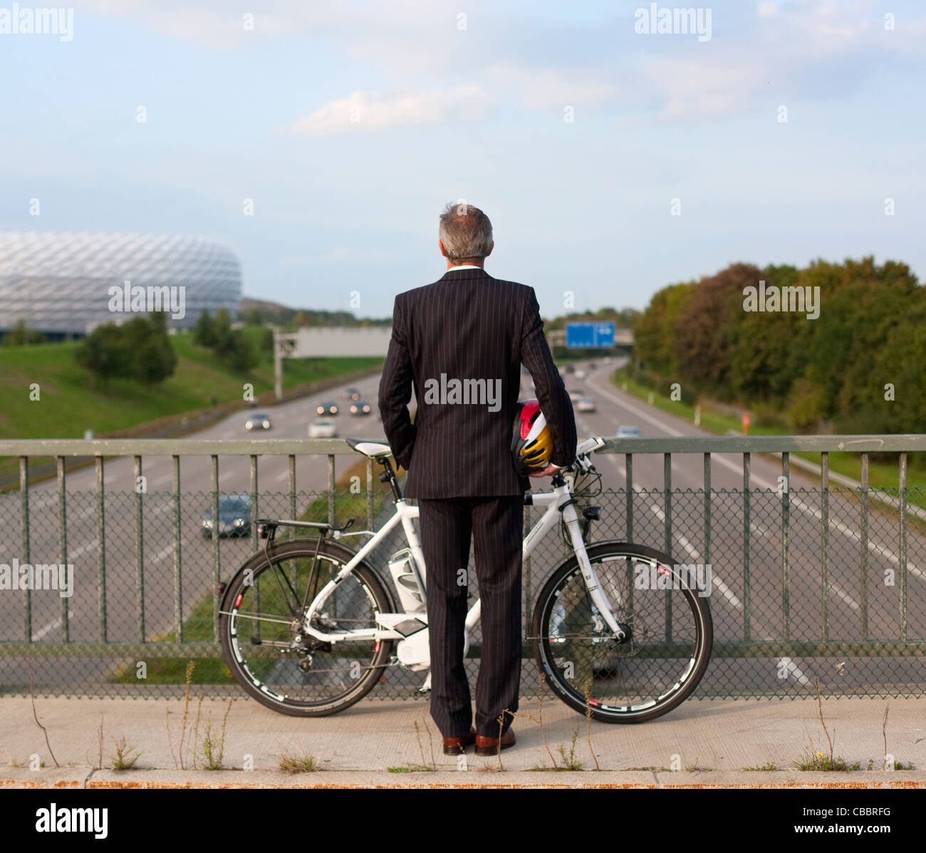 Businessman riding bicycle on bridge Banque D'Images