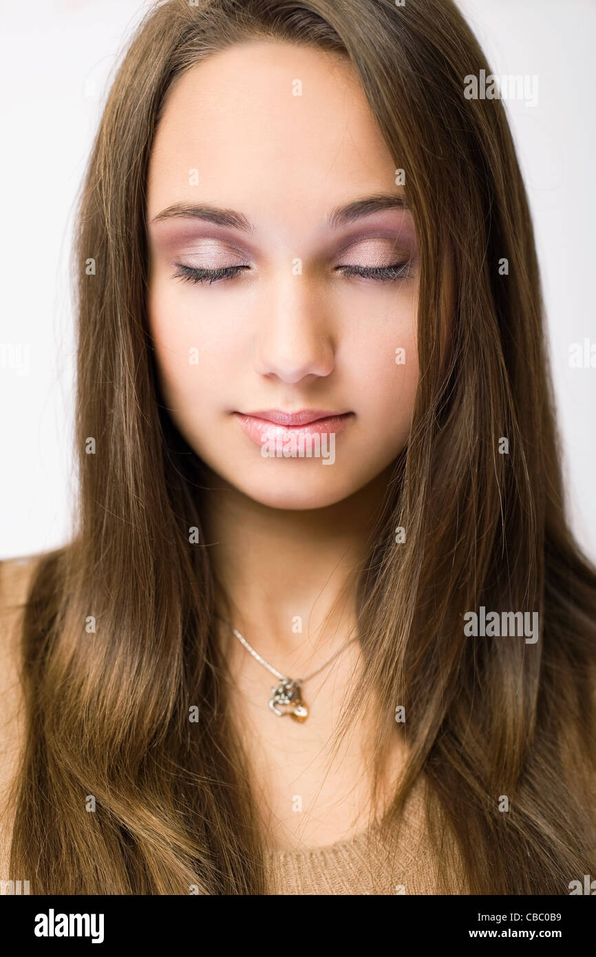 Closeup portrait d'une superbe jeune brunette dans un miroir avec les yeux fermés. Banque D'Images