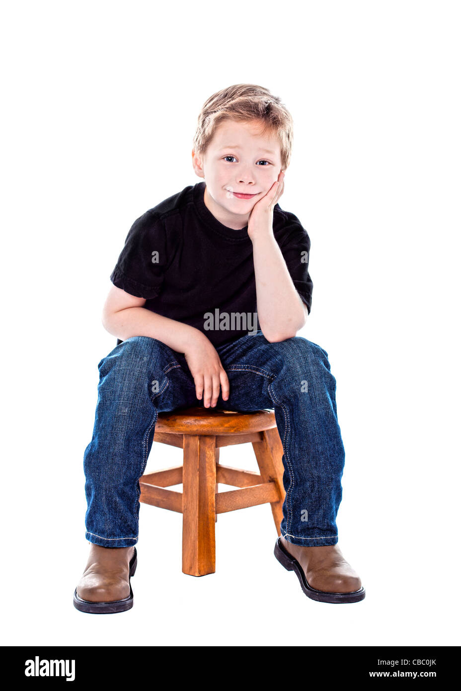 Cute boy dans studio assise sur un tabouret Banque D'Images