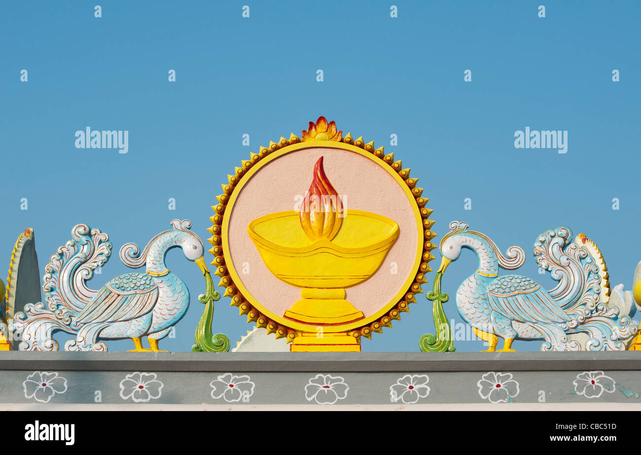 Temple indien sculpture représentant des oiseaux entourant une lampe et des flammes. Puttaparthi, Andhra Pradesh, Inde Banque D'Images