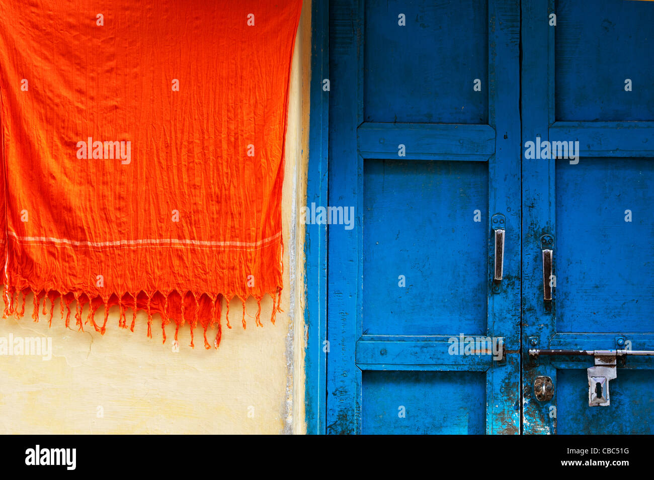 Matériel orange à côté de portes bleues suspendues d'une maison de village indien. Praedsh landhra, Inde Banque D'Images