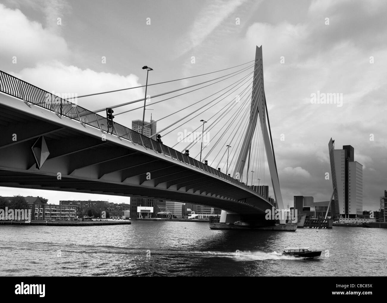 Un taxi d'eau passe sous le pont Erasmus, Rotterdam, Pays-Bas - image monochrome Banque D'Images