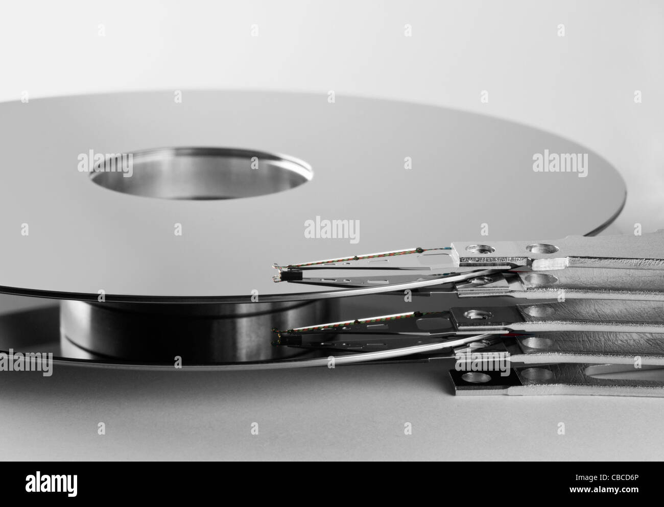 Détail d'un plateau de disque dur séparé avec le bras actionneur en gris clair retour Banque D'Images