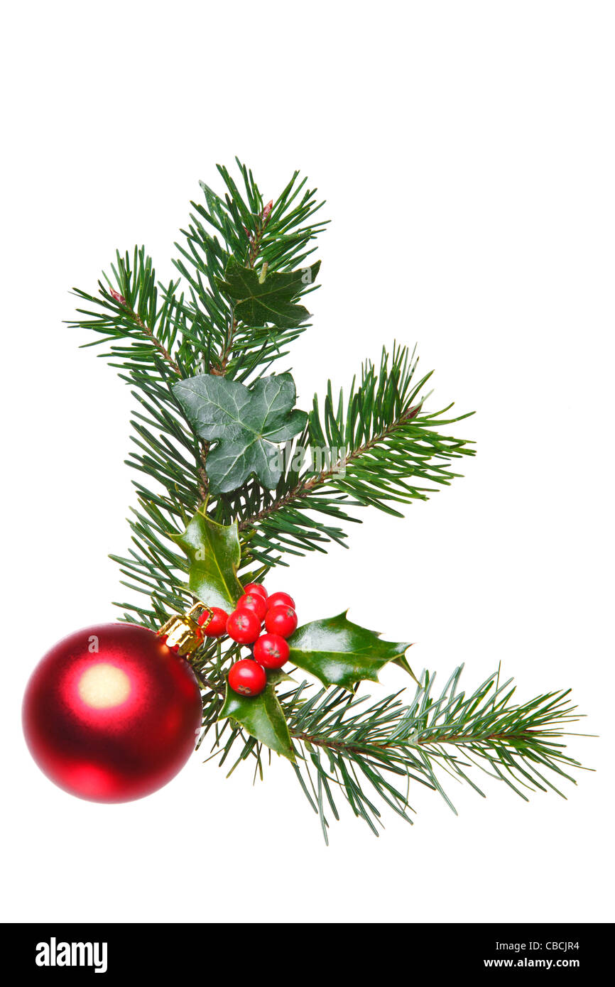 Photo d'une décoration de Noël fait avec Holly, fruits rouges, l'épinette, du lierre et une babiole rouge, isolé sur un fond blanc. Banque D'Images