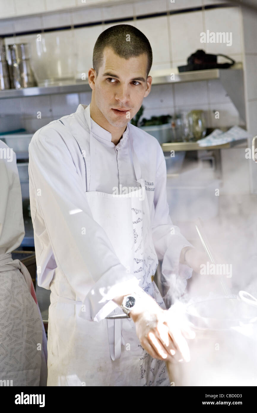 Chef standing à l'eau pot dans cuisine commerciale Banque D'Images