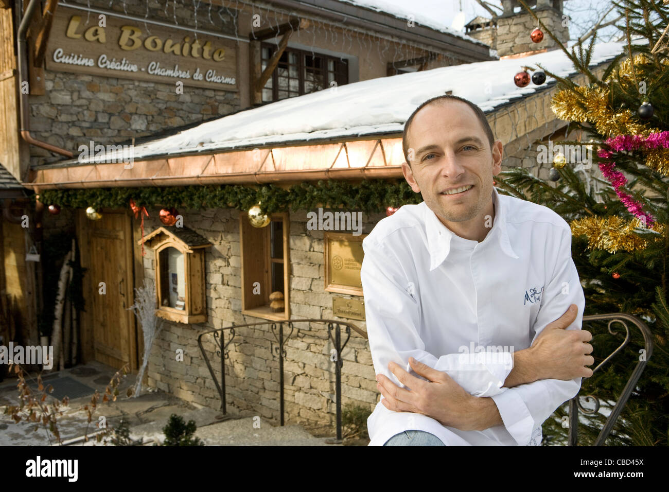Chef standing in front of mountain resort, portrait Banque D'Images