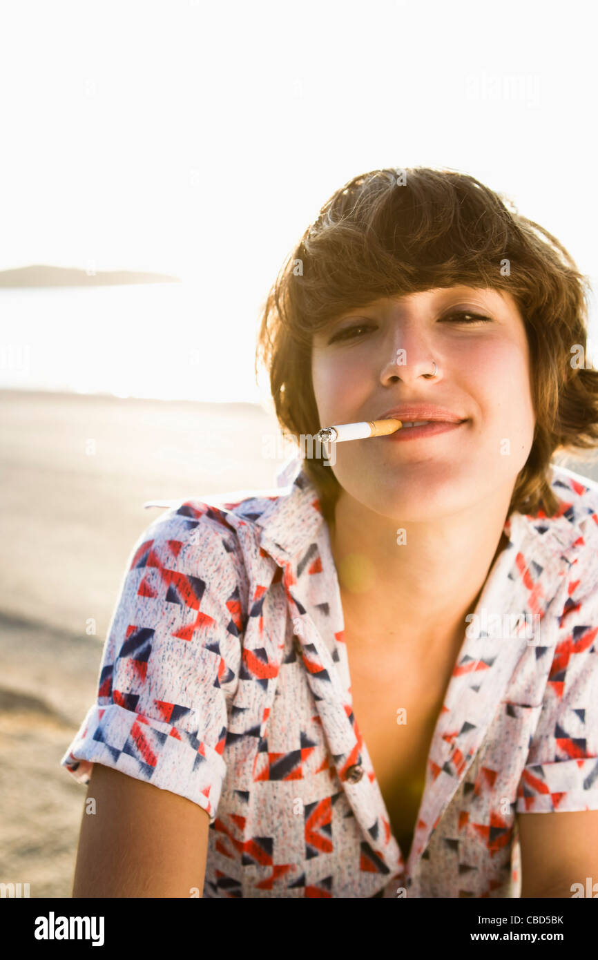 Femme cigarette on beach Banque D'Images
