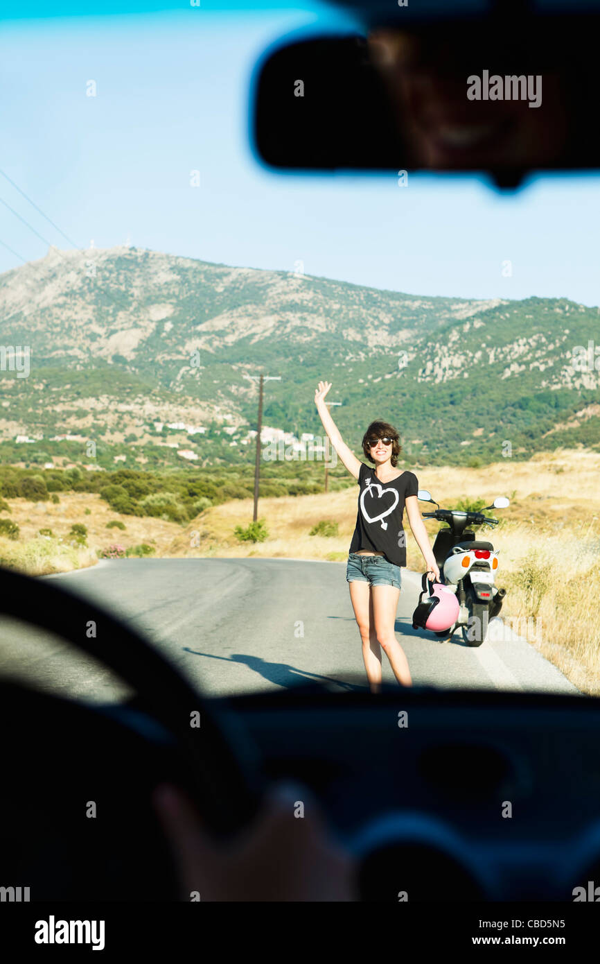 Femme avec ventilés sur route scooter Banque D'Images
