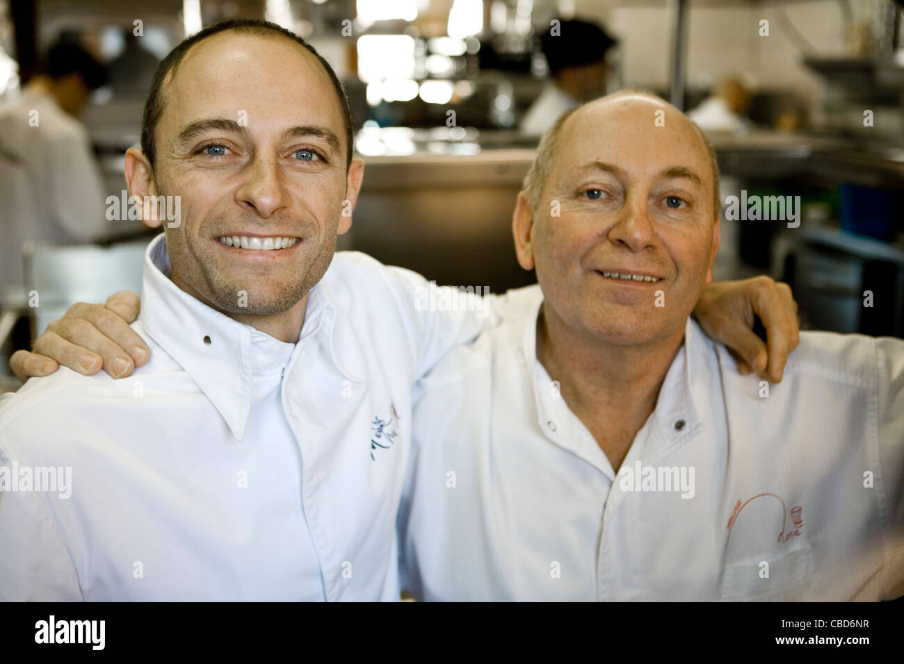 Père et fils dans l'équipe de chef de cuisine commerciale, portrait Banque D'Images
