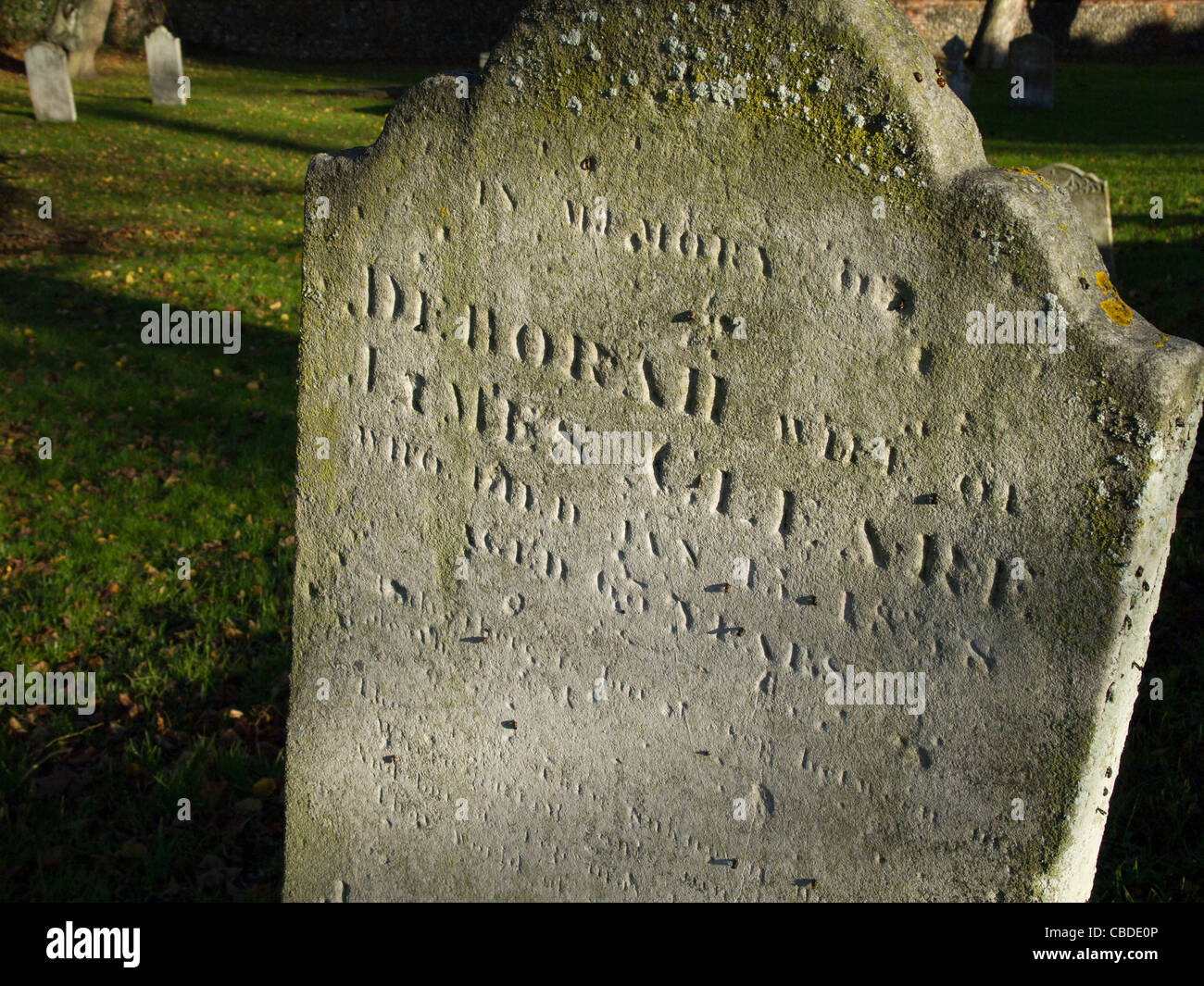 Une vieille pierre tombale portant des noms qui sont patinées par le temps et presque illisible. Banque D'Images