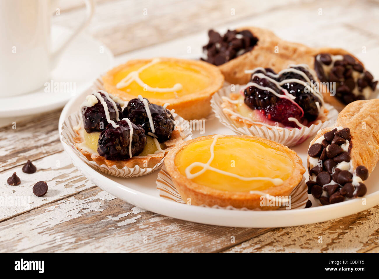 Plateau de fruits mini tartes et café sur une table en bois rustique Banque D'Images