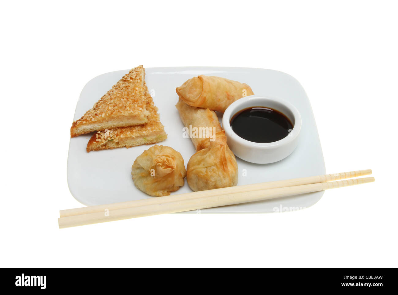 En-cas chinois crevettes rôties, crêpes, pains, wonton et un bol de sauce de soja sur une assiette avec des baguettes Banque D'Images