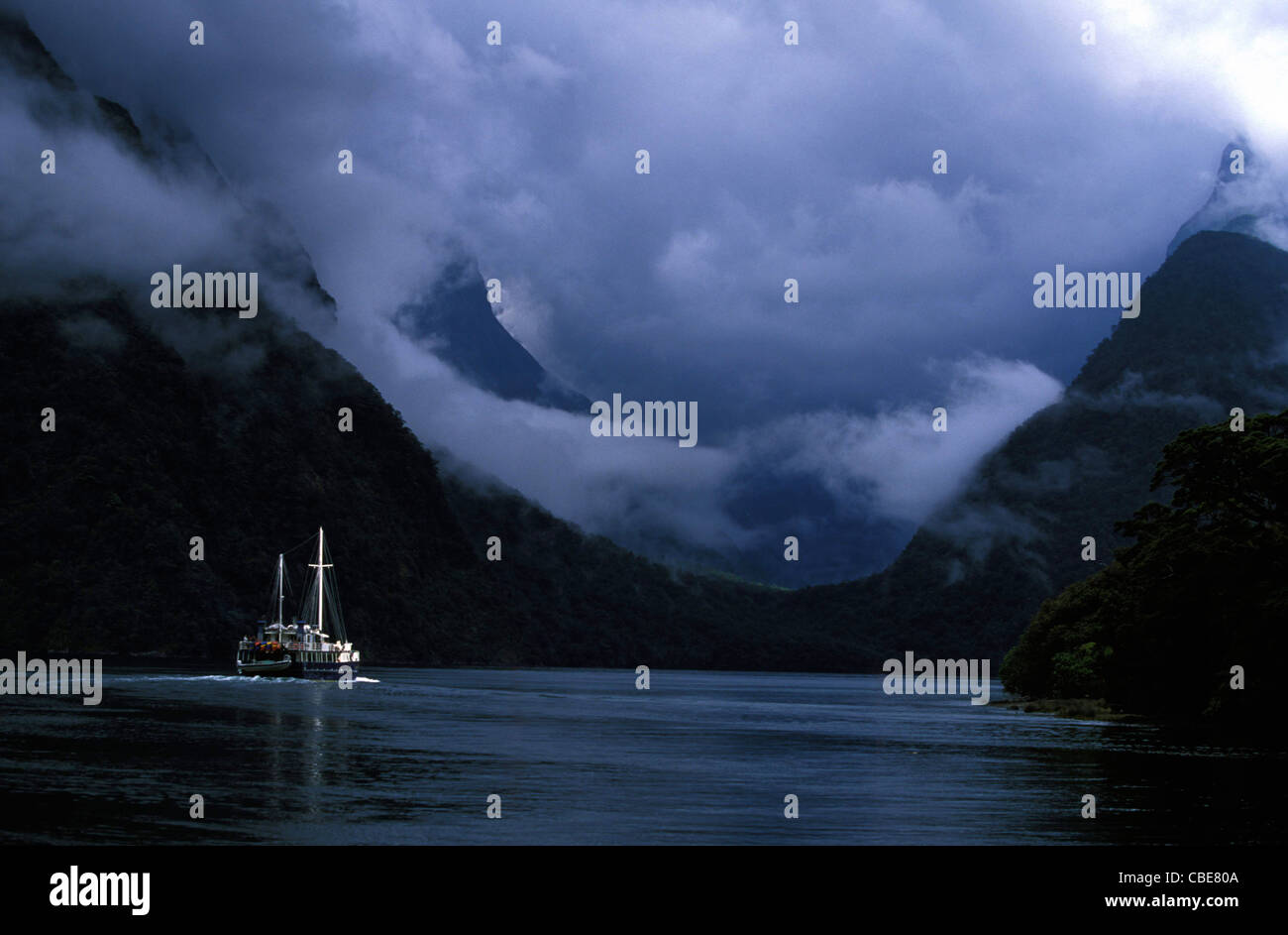 Voyageur intrépide, Milford Sound. Les captures de Sun le bateau tandis qu'il déclenche dans l'inconnu. Est-ce qu'il y a danger à venir ? Banque D'Images Voyageur intrépide, Milford Sound. Les captures de Sun le bateau tandis qu'il déclenche dans l'inconnu. Est-ce qu'il y a danger à venir ? Banque D'Images