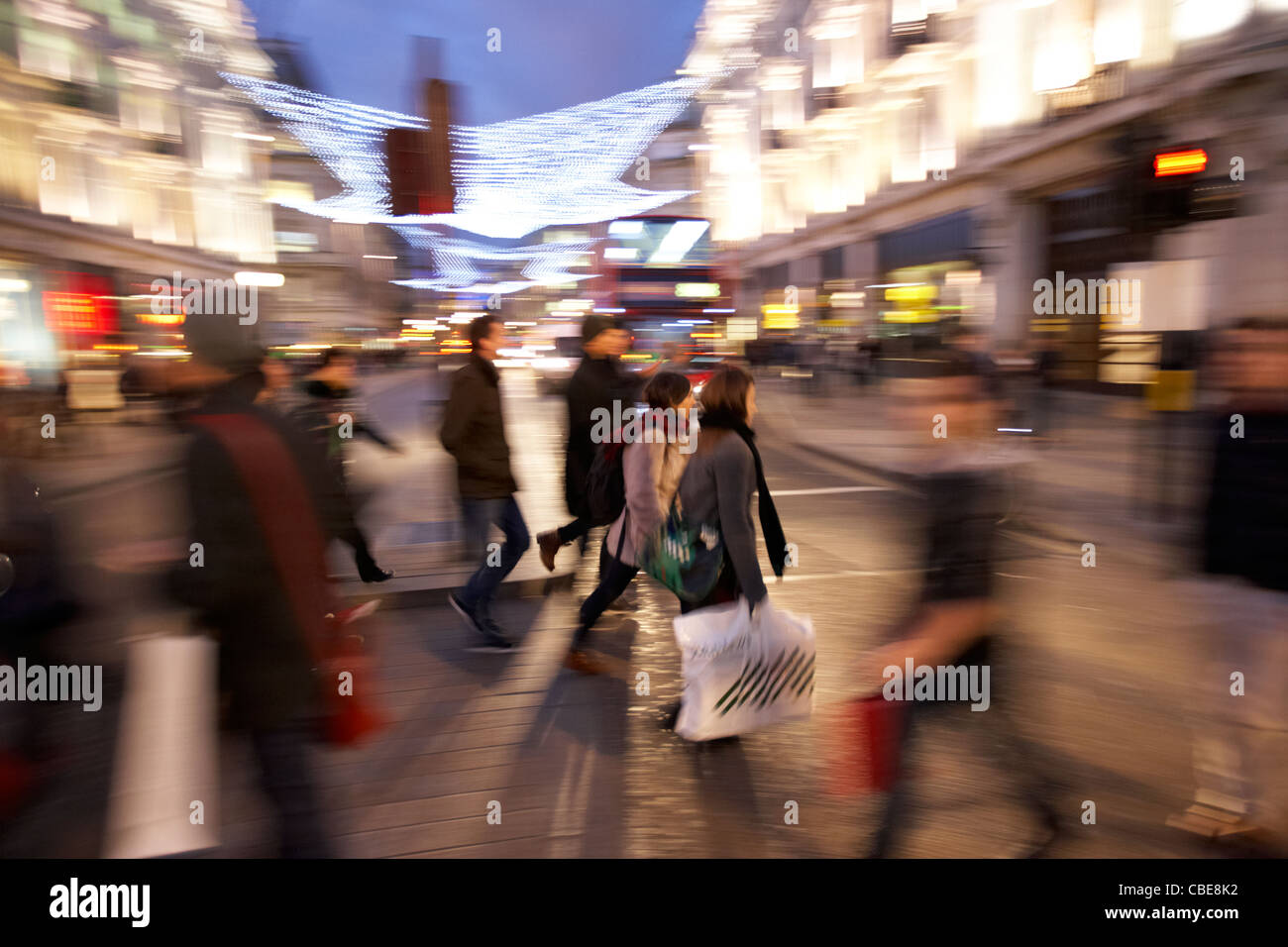 Les personnes qui traversent occupé à Oxford street Christmas shopping Londres Angleterre Royaume-Uni uk flou délibéré d'action (PAN) Banque D'Images