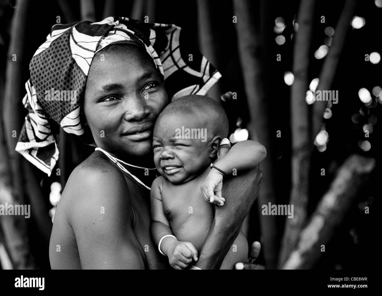 Femme Mucubal avec son bébé pleurer dans ses bras, Virie, Angola Banque D'Images