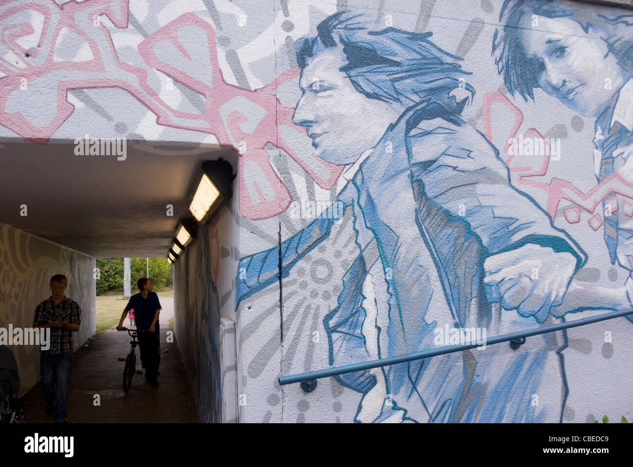 Deux garçons marcher le passage souterrain admirer variée des murales, les enfants de l'école ethnique A57 Sheffield Parkway, UK Banque D'Images