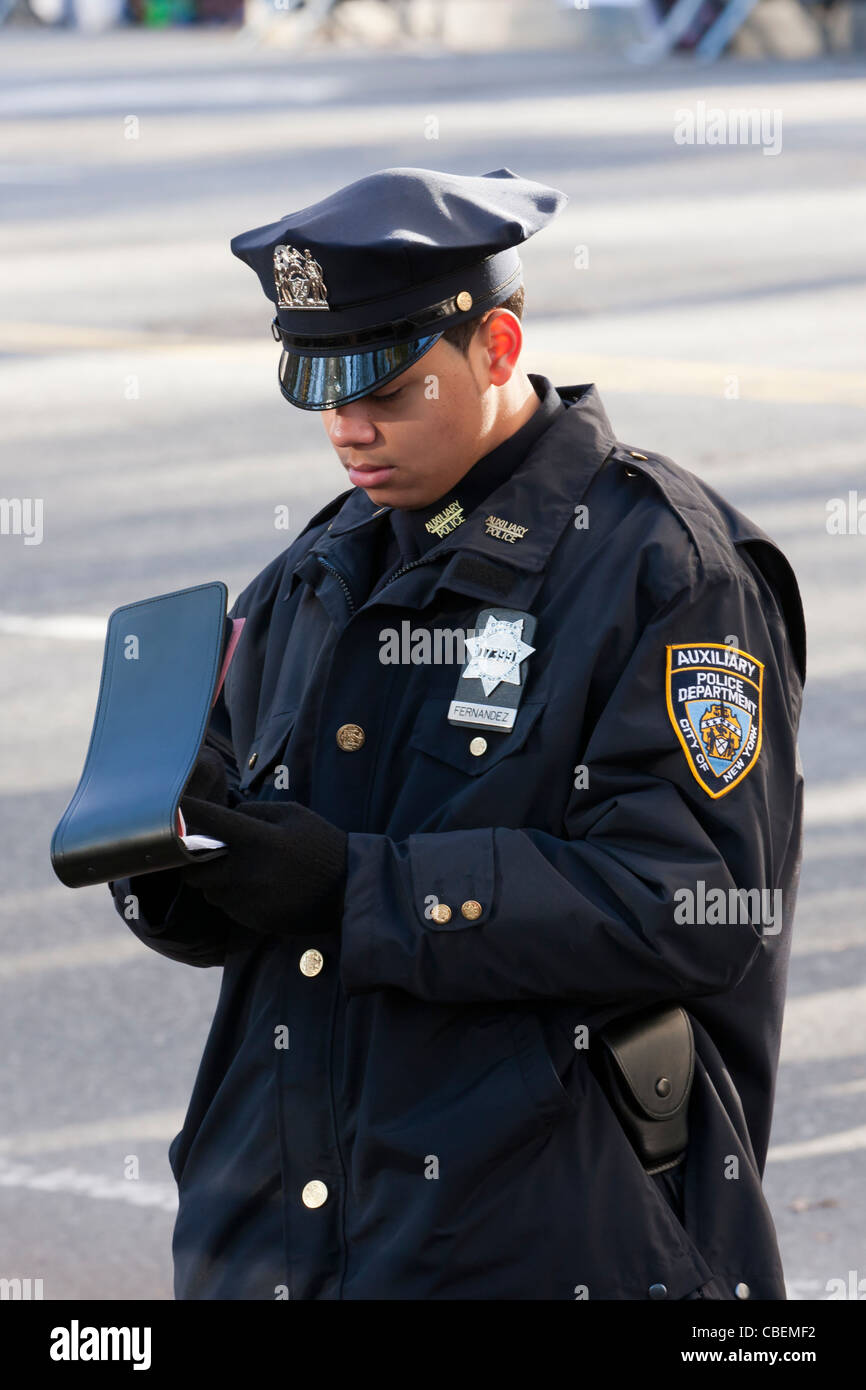 Un agent de police auxiliaire de la police prend des notes pendant l'exercice de ses fonctions lors d'un défilé dans la ville de New York. Banque D'Images