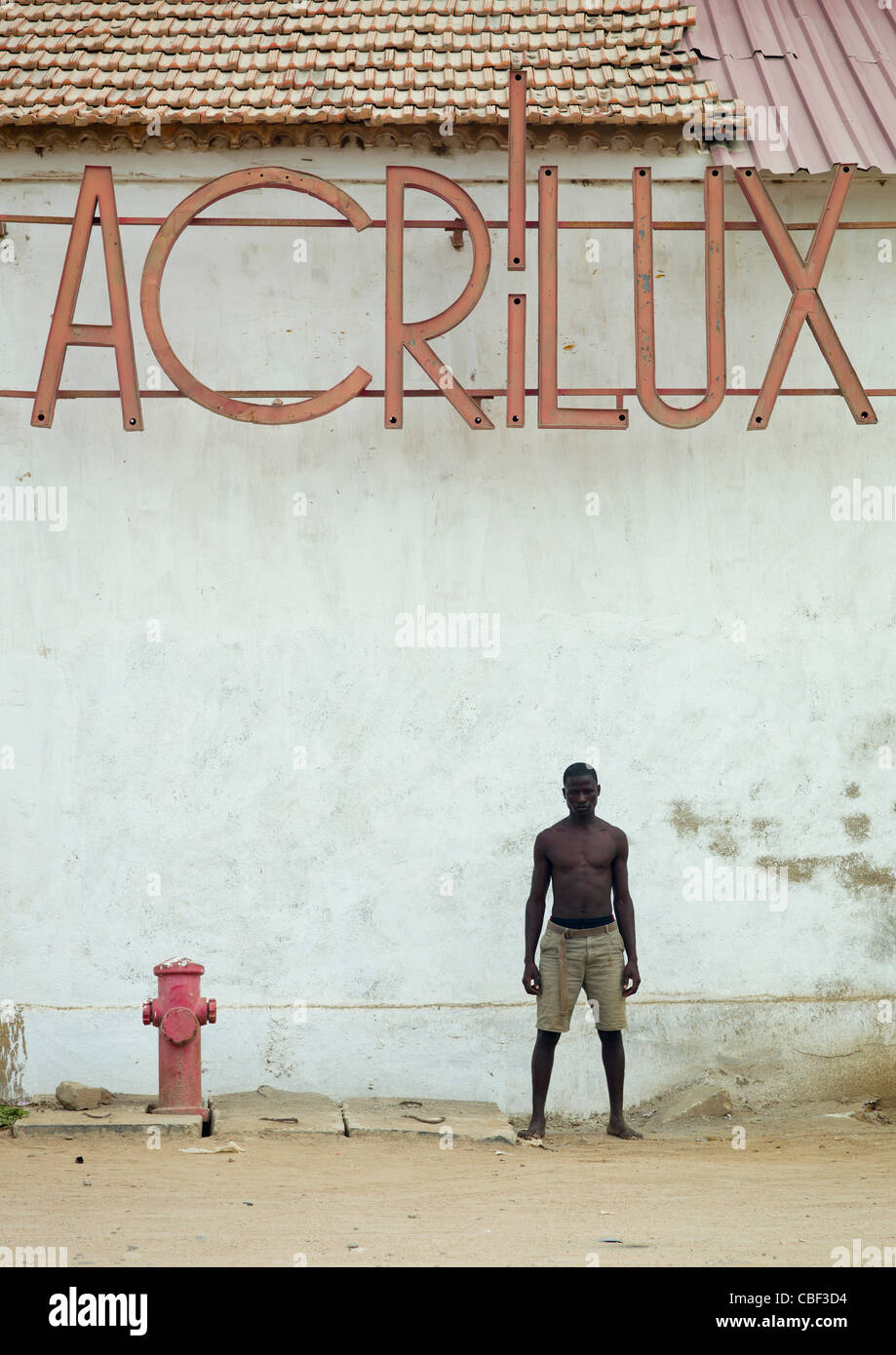 L'homme en face d'un ancien magasin Acrilux à Benguela, Angola Banque D'Images
