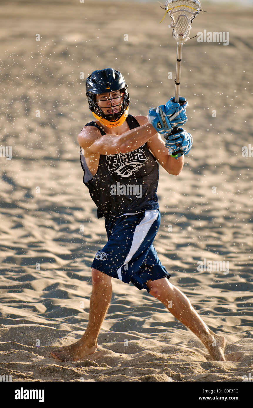 Un athlète de crosse masculin jouant sur la plage. Banque D'Images