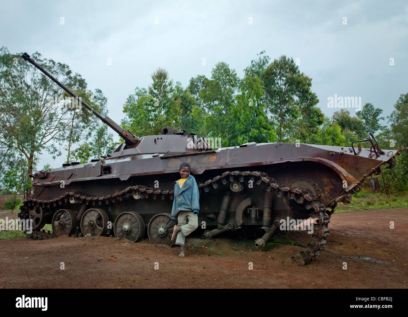 Garçon en face d'un char d'épave d'une guerre civile, l'Angola, Bie Banque D'Images