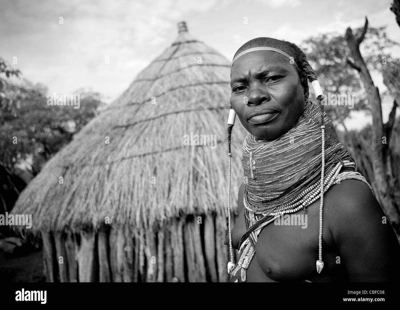 Mwila femme avec un collier Vilanda devant sa hutte, Chibia, Angola Banque D'Images