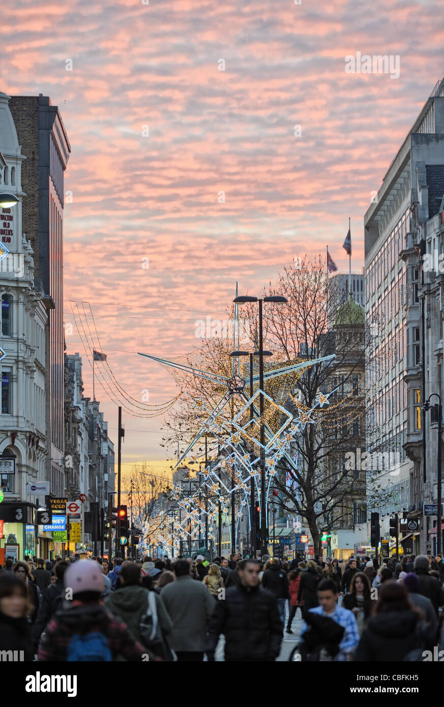 Shoppers on une Oxford Street, London, UK, au coucher du soleil Banque D'Images