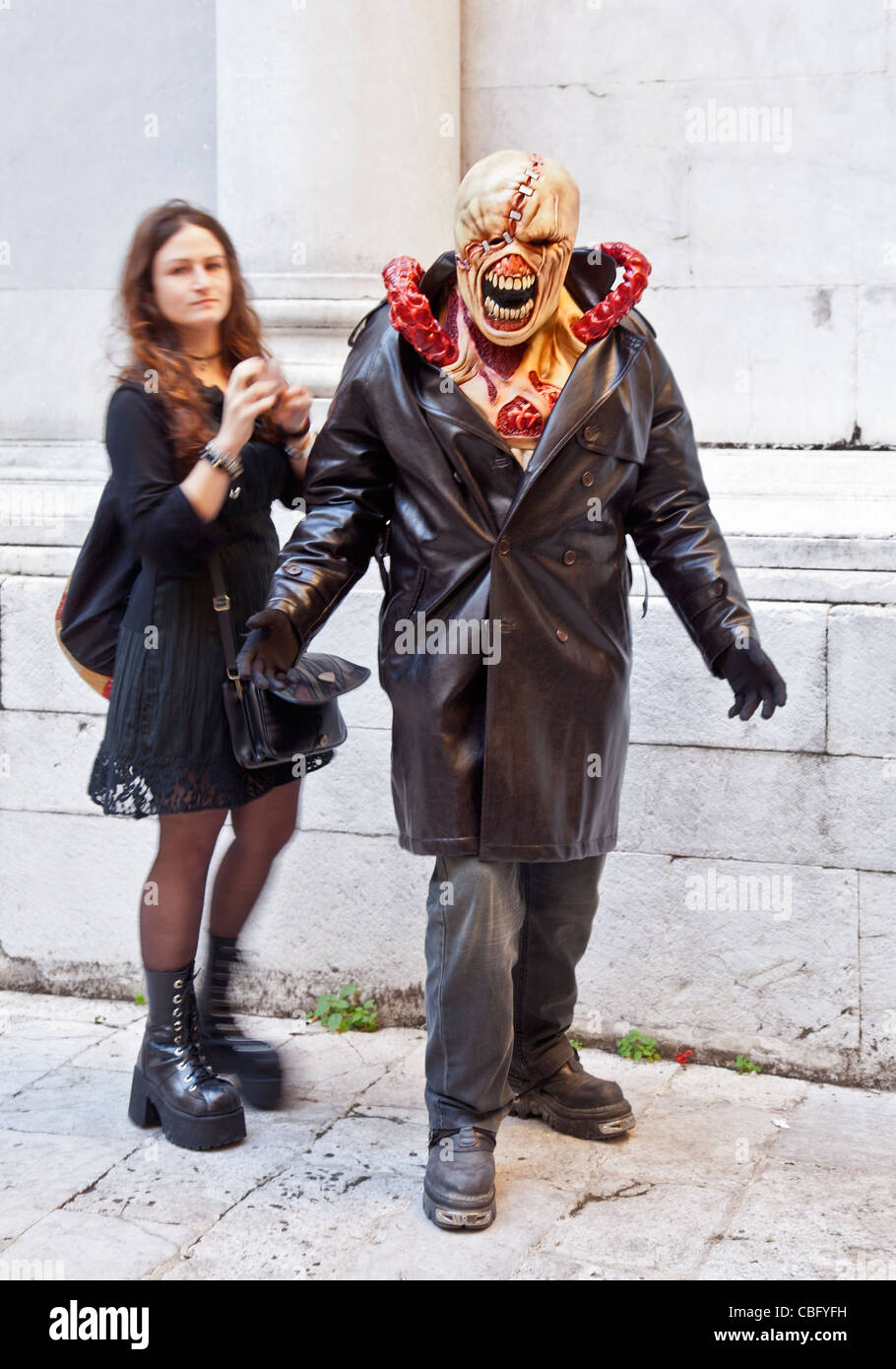 Jeune homme habillé comme Nemesis de Resident Evil 2 videogame Lucca Comics and Games Festival. Jeune femme l'a aidé à se préparer. Banque D'Images