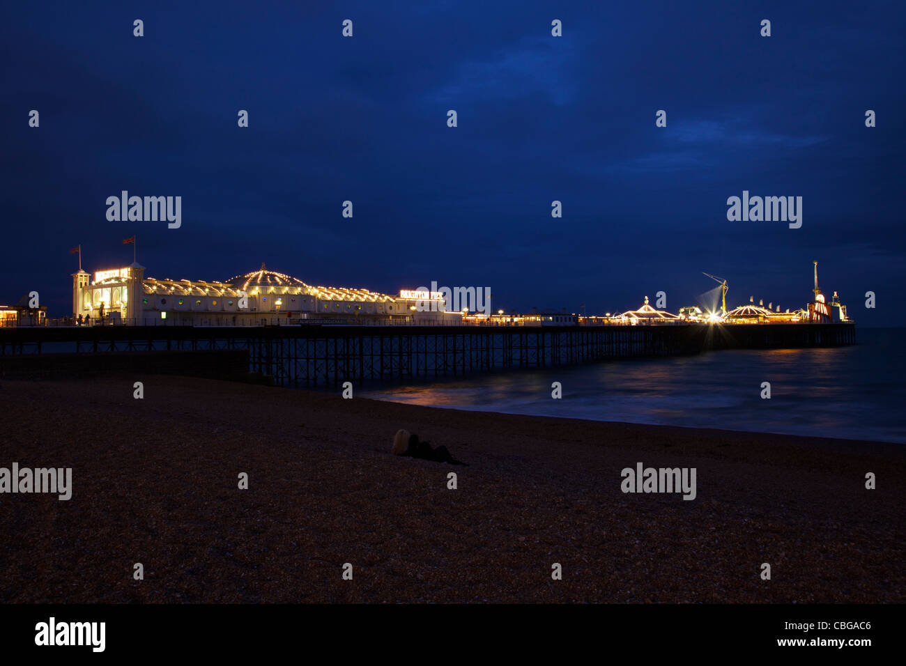 Brighton Pier au crépuscule avec young couple on beach, West Sussex, England, UK, Royaume-Uni, GO, Grande-Bretagne, Îles britanniques Banque D'Images