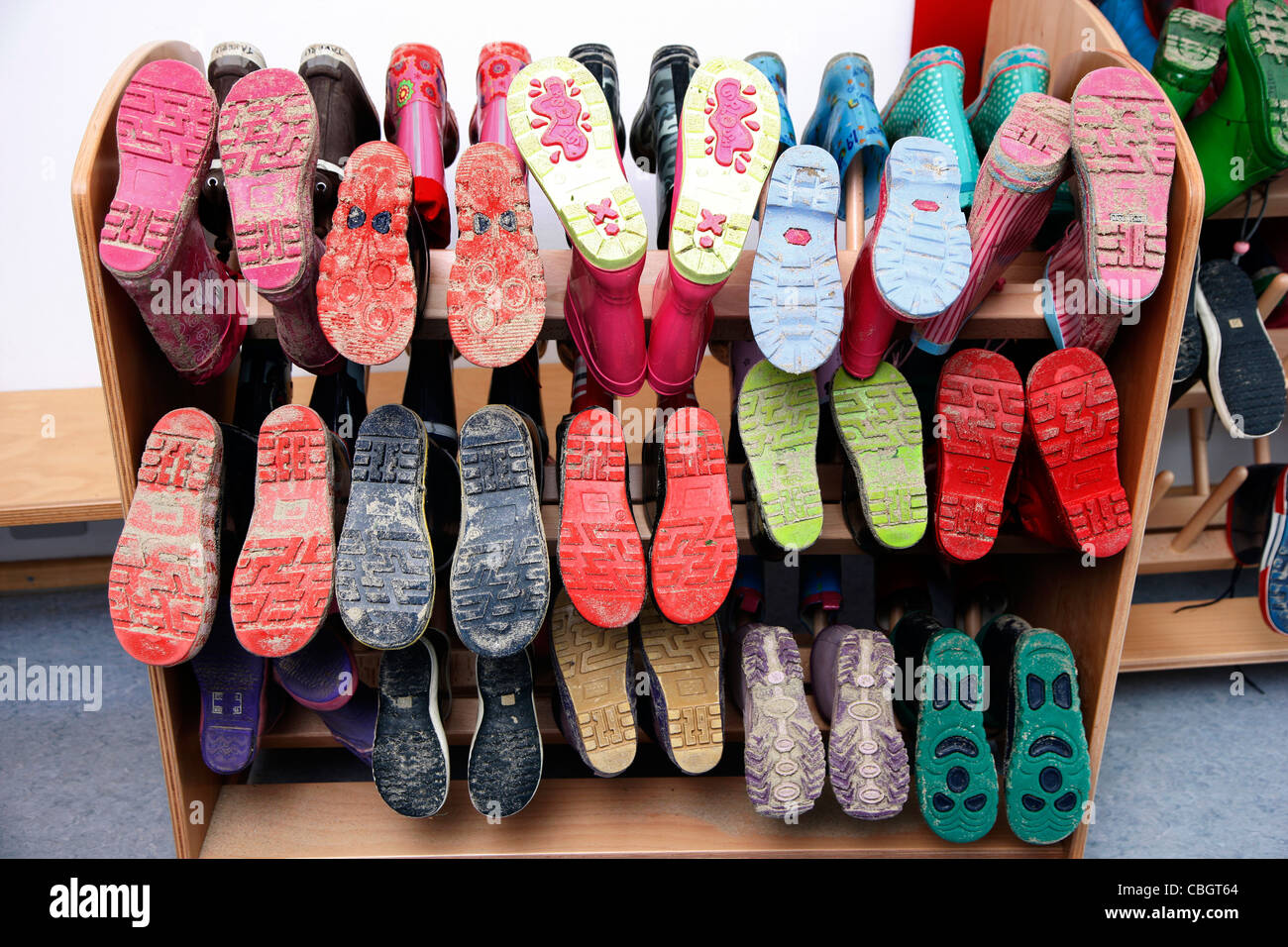 Séchage de bottes en caoutchouc sur la grille d'un centre de jour pour les enfants. Banque D'Images