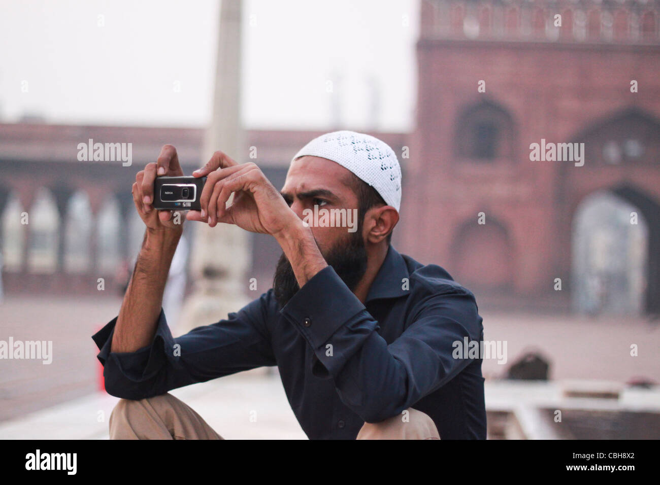 Un musulman photographiant avec caméra mobile à l'intérieur de Jama Masjid, Old Delhi, Banque D'Images