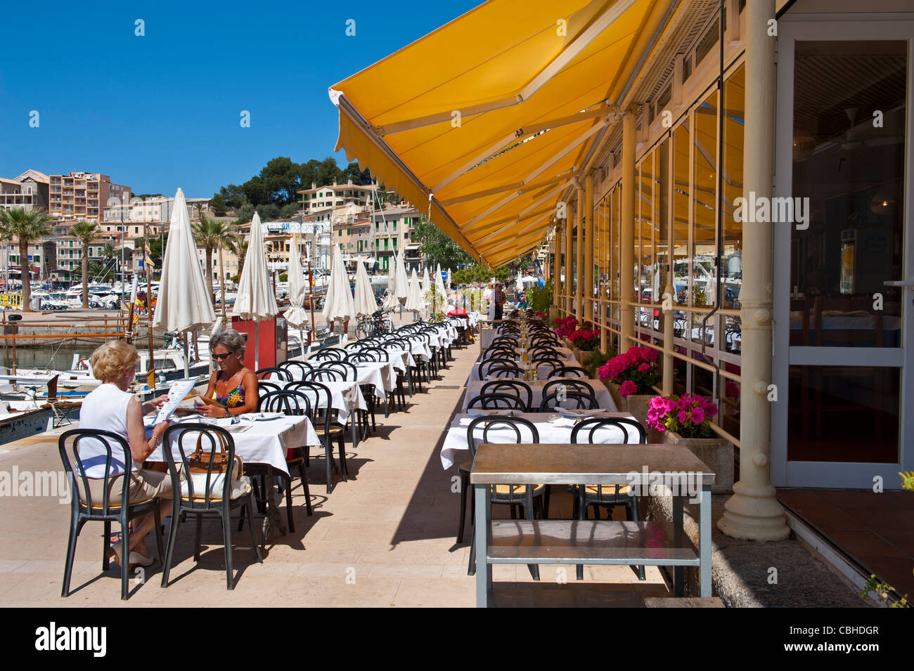 Restaurant espagnol presque déserté Alfresco Sun Restaurant avec deux visiteurs appréciant le déjeuner sur une terrasse ensoleillée calme à Port de Soller Mallorca Espagne Banque D'Images