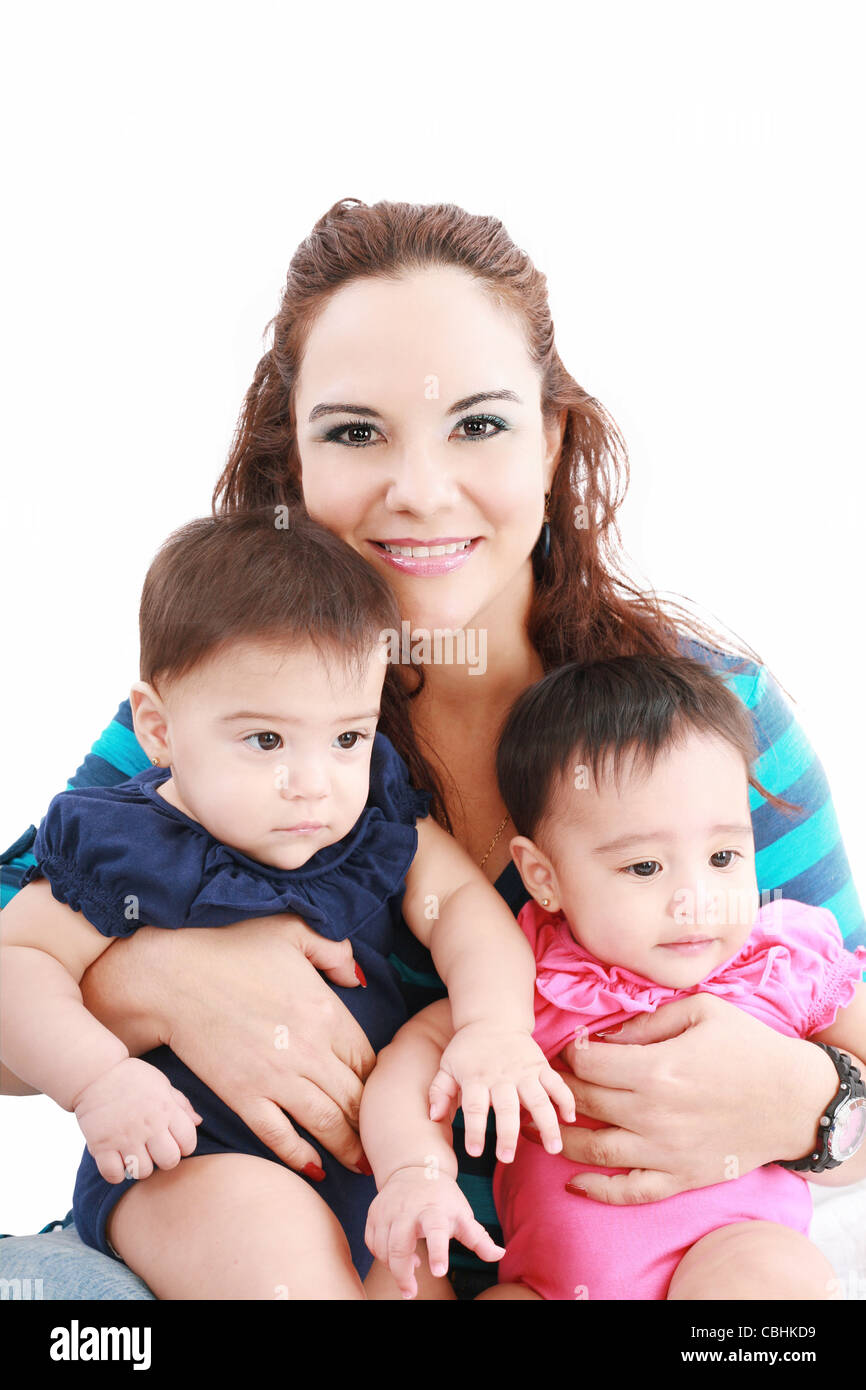 Heureux jeune mère avec deux bébés sur un fond blanc. Banque D'Images