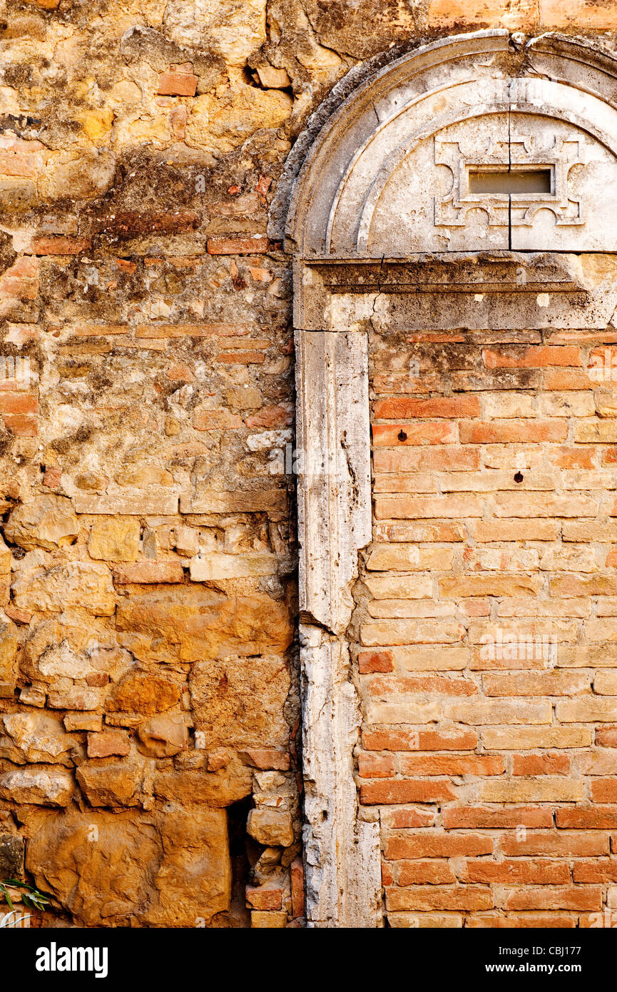 Ancien mur dans le village médiéval de San Quirico d'Orcia, site classé au Patrimoine Mondial de l'Unesco, Toscane, Italie Banque D'Images