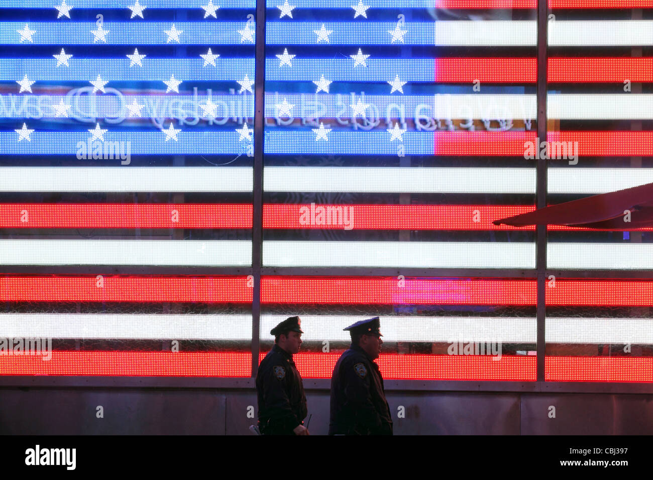 Deux policiers de New York à pied passé, Allumé Stars & Stripes, United States Flag, Times Square, New York City, NY, USA Banque D'Images