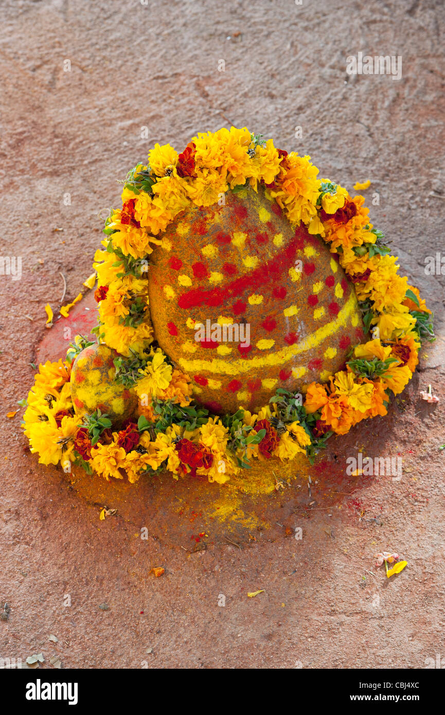 Temple d'un sanctuaire hindou stone entouré d'une guirlande de fleurs dans un village de l'Inde rurale. L'Andhra Pradesh, Inde Banque D'Images