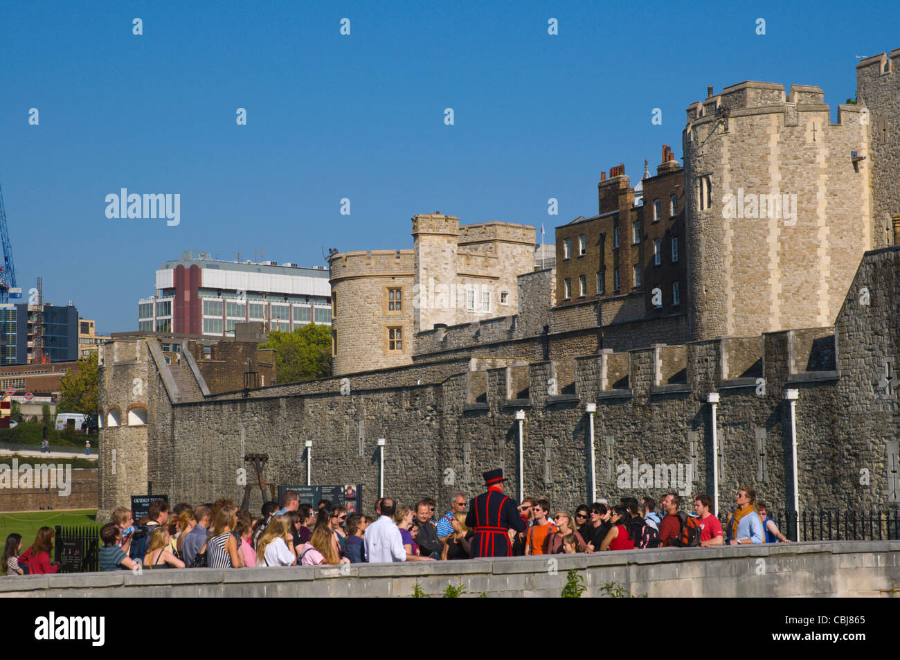 Acteur dans l'habillement, le Beefeater donnant une visite guidée de la Tour de Londres tour extérieur complexe forteresse Hill area central London Banque D'Images